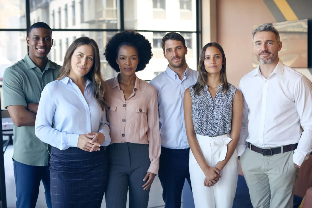 Portrait Of Smiling Multi-Cultural Business Team Standing In Modern Office